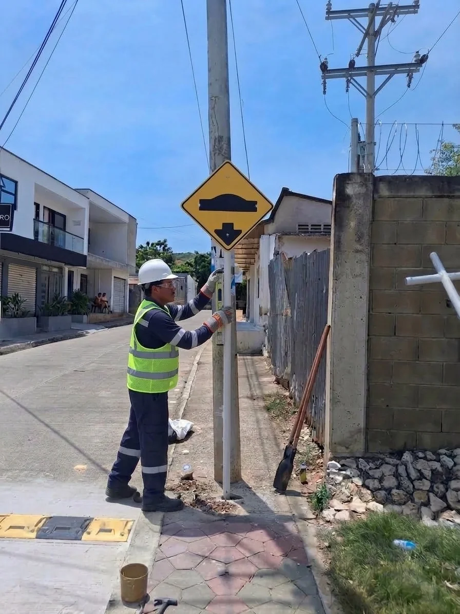 Trabajador instalando señal de tránsito en vía pública